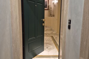 A hallway with a dark green door, marble flooring, and a statue on the wall. - Exclusive luxury penthouse located in Piazza D’Azeglio in Viareggio, on the third floor with elevator, featuring high-end finishes and a stunning panoramic sea-view terrace.The apartment, approximately 110 sqm, is arranged over two levels and enhanced  (Viareggio)