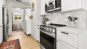 A modern kitchen with white cabinetry, a stainless steel stove, a microwave, and a built-in oven. - Park the car and enjoy Mount Dora! <br>Stay just a 1/2 Mile from Downtown Mount Dora and Lake Dora in our beautifully restored 1950s duplex. <br>Walk to shops & dining! Features fast WiFi, workspace, patio, free parking, and boat parking! (Mount Dora)