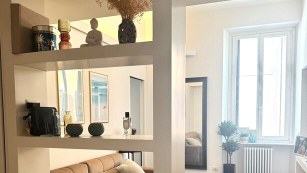 A modern living room with a sofa, a coffee table, and a large window. - Colosseum Luxury Retreat (Roma)