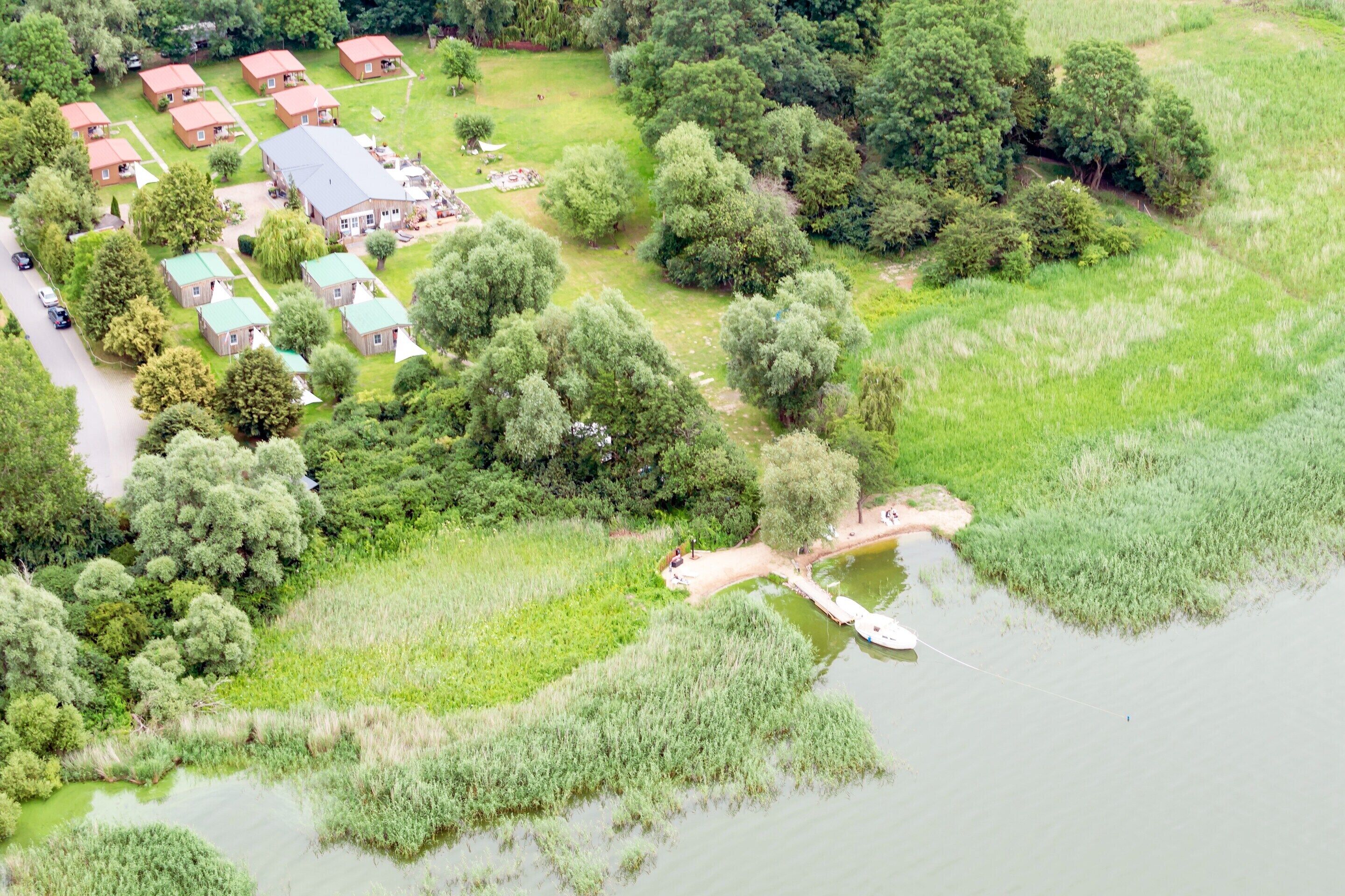 An aerial view of a residential area with multiple houses, a dock, and a body of water.
