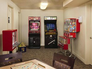 Een kamer met speelautomaten, een automaat en een tafel met een spel.