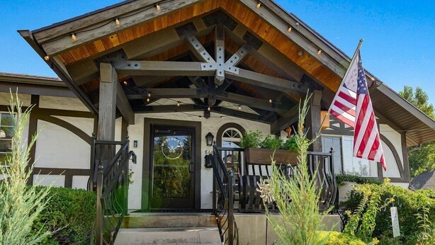 Un bâtiment doté d’une façade en bois, d’une porte noire et d’un drapeau américain.