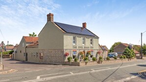 Un edificio a due piani con un cartello che riporta 'The Five Dials Inn'.