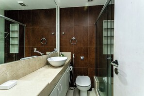 A modern bathroom with a large sink, two towel rings, a toilet, and a glass shower enclosure. -  Leme 3 Quartos Conforto 2 min Praia (Rio de Janeiro)