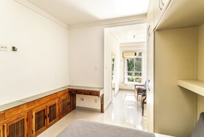 A spacious room with a wooden cabinet, a bed, and a view of the outdoors. -  Leme 3 Quartos Conforto 2 min Praia (Rio de Janeiro)