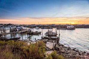 A marina with boats docked, a rocky shoreline, and a sunset in the background. - Chaloupe - Direct sea view 50m from the beach (Saint-Hilaire-de-Riez)