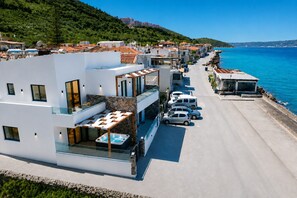 Un hôtel moderne doté d’une piscine, de nombreux balcons et offrant une vue sur la mer.