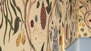 A wall with a detailed botanical pattern.