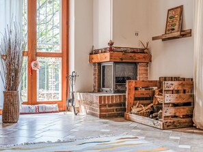 A cozy room with a fireplace, a wicker basket, and a rustic wooden bench. - Quaranta by Interhome (Cervo)