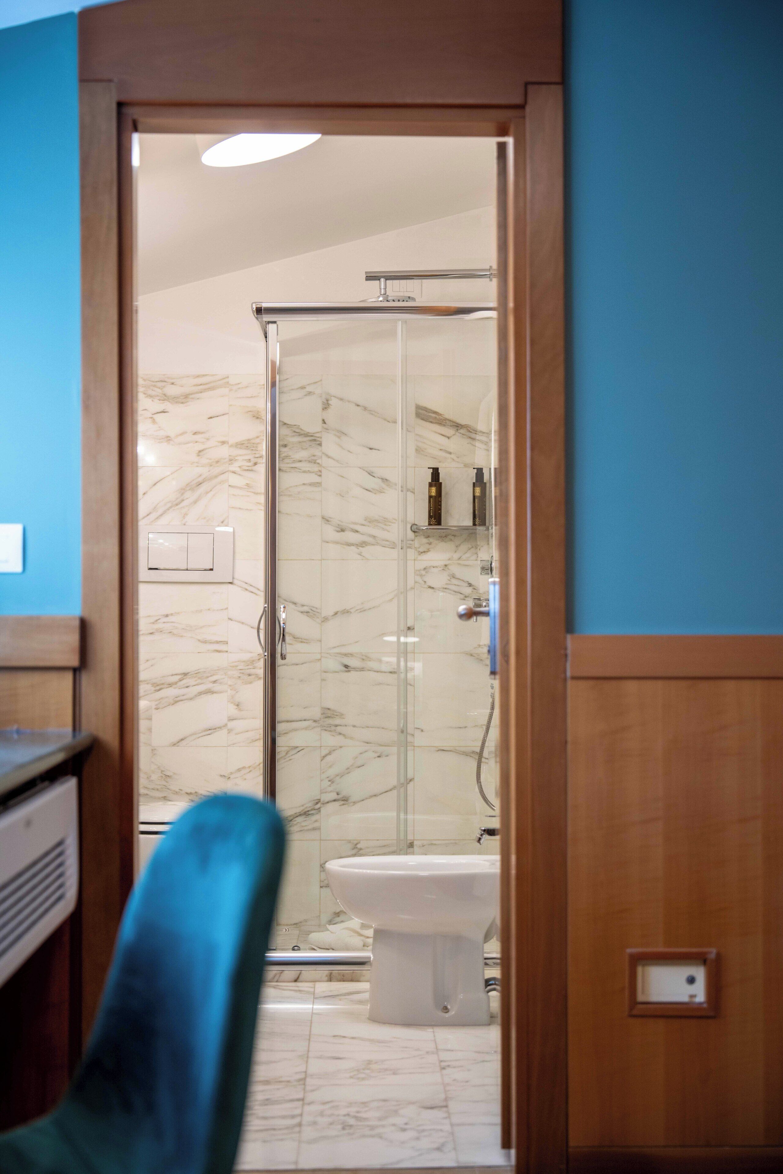 Un bagno con cabina doccia in vetro, un water e un lavandino.