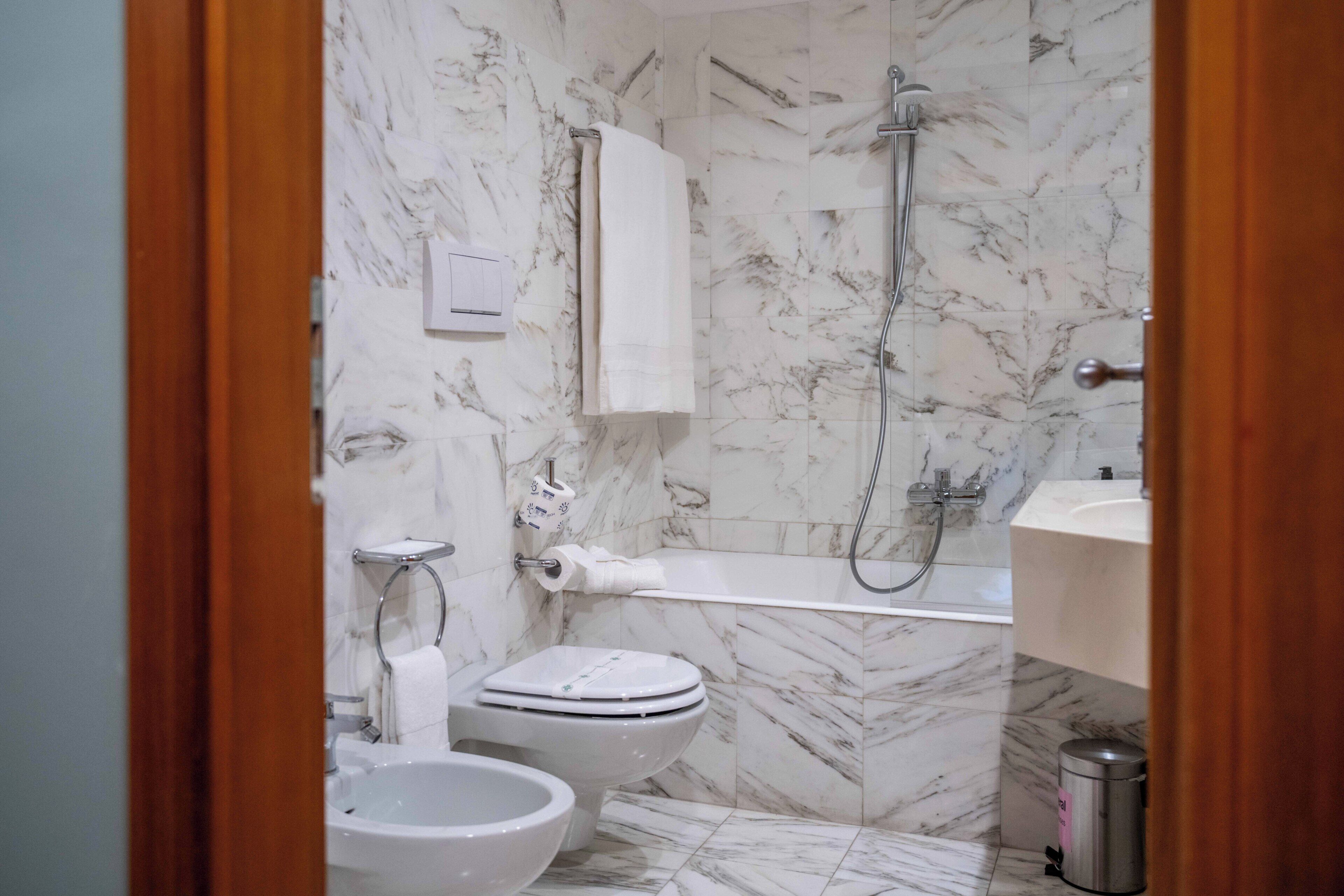 Un baño con inodoro, bidé y ducha.