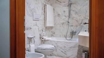 Un baño con inodoro, bidé y ducha.