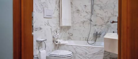 A bathroom with a toilet, bidet, and shower.