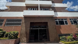 A tall building with a modern architectural design, featuring multiple balconies and a central entrance with glass doors. - Prime Center View - Beautiful view. Do it all on foot! (São Lourenço)