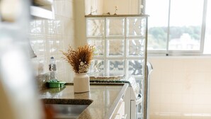 A kitchen with a granite countertop, white cabinets, and a window with a view. - Prime Center View - Beautiful view. Do it all on foot! (São Lourenço)