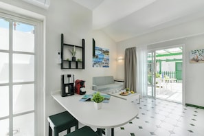 A modern kitchen with a dining area, a coffee machine, a small table, and a view of the outside. - Campo Golf 26 by VillaGranCanaria (Las Palmas de Gran Canaria)