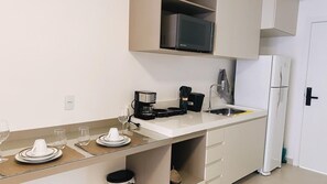 Una cocina moderna con microondas, cafetera y refrigerador.
