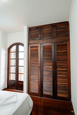 Ein Schlafzimmer mit einem Bett, einem Holzschrank und einem Fenster.