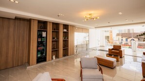 A modern lobby with wooden shelving, seating, and a view of the outside.