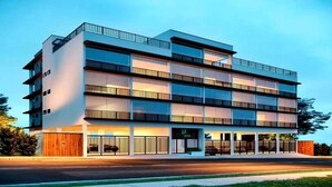 A multi-story building with balconies, a covered entrance, and a visible sign. - High Standard Flat - Best area of the city! (São Lourenço)