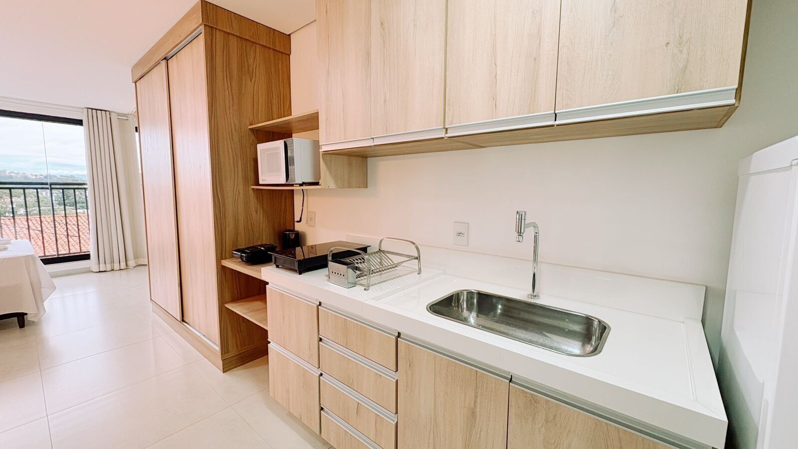 Une cuisine moderne dotée d’un évier encastré, de meubles en bois et offrant une vue sur l’extérieur.