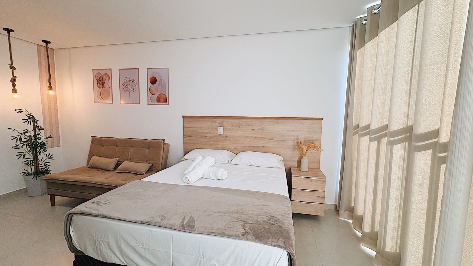 Une chambre à coucher avec un lit, une table de chevet, une lampe et des œuvres d’art murales.