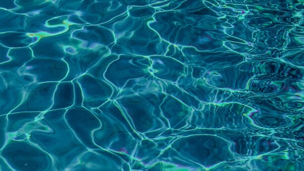 Un gros plan sur de l’eau claire, où l’on peut voir des ondulations et des reflets.