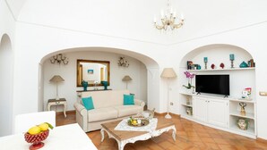 Een woonkamer met een bank, salontafel, televisie en decoratieve objecten.