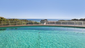 A clear blue pool with a view of the sea and distant land. - Apartment 'Sa Calma 2 - 1D' with Sea View, Wi-Fi and Air Conditioning (Begur)