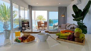 Una mesa de desayuno con frutas, un tazón y un vaso de jugo de naranja.