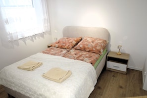 A bedroom with a bed, pillows, a bedside table, and a nightstand. - New apartment in Wisełka (Wisełka)