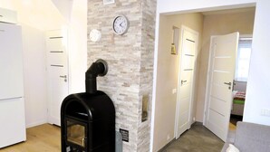 A room with a fireplace, white doors, a clock, and a grey sofa. - New apartment in Wisełka (Wisełka)