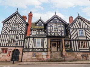 Edifici de tipus Tudor tradicional amb façana de fusta en negre i blanc, una entrada destacada amb el rètol 'LION & SWAN' i un senyal de carrer que diu 'WEST STREET'.