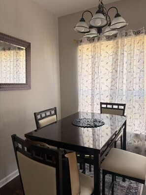 Ein Essbereich mit Tisch, Stühlen und einer Chandelier.