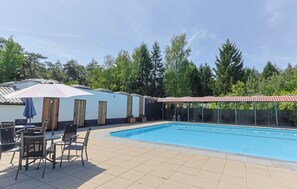 A swimming pool with a tiled deck, a covered seating area, and a row of doors. - De Rode Vos - Enjoying the forest (Lemmer)