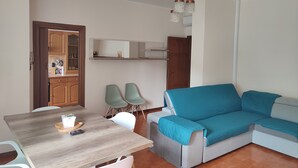 A compact living space with a dining table, two chairs, a sofa, and a kitchenette. - Green Ledro Lake Apartment -A few steps from the Ponale Trail - 800m from the Lake (Molina di Ledro)