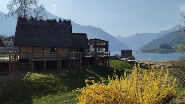 A lakeside village with traditional buildings, wooden walkways, and mountains in the background. - Green Ledro Lake Apartment -A few steps from the Ponale Trail - 800m from the Lake (Molina di Ledro)