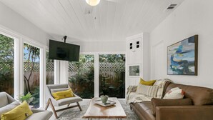 A living room with a sofa, armchair, coffee table, and a flat-screen TV mounted on the wall. - Pool Home Oasis - Home for five (Tampa)