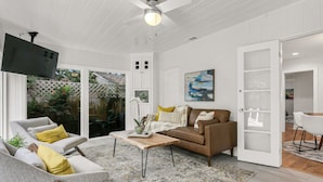 A living room with a sofa, coffee table, and a television. - Pool Home Oasis - Home for five (Tampa)