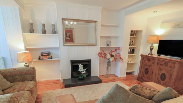 Ein Wohnzimmer mit Kamin, Fernseher und Bücherregal.