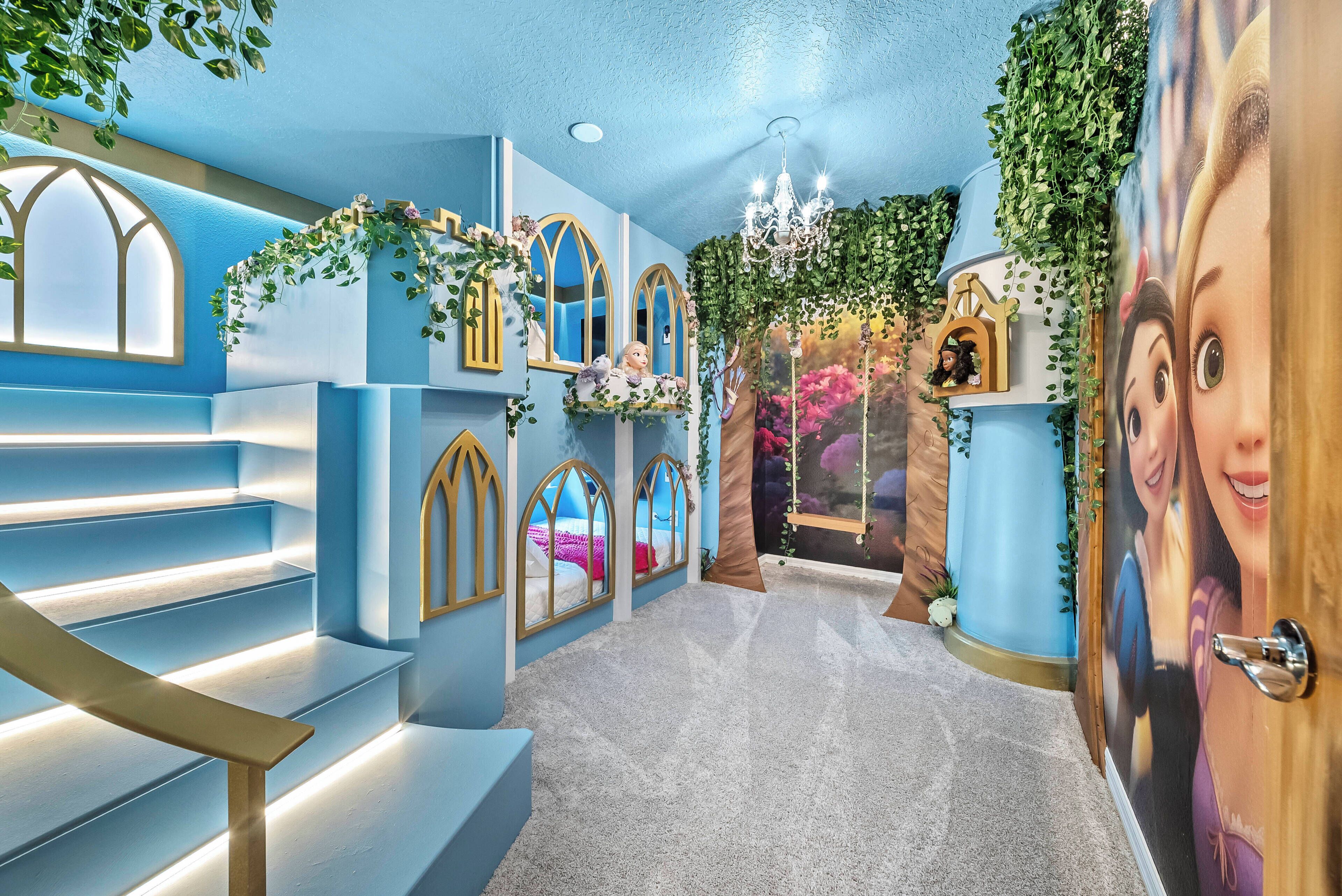 A hallway with a staircase, decorative mirrors, and a chandelier.