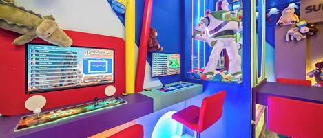 Una habitación colorida con una consola de videojuegos 3D, peluches y una figura de juguete grande.