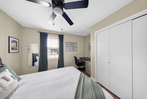 Queen bedroom with ceiling fan, blackout curtains, and a built-in desk for remote work - Bike garage, game room, near downtown (Bentonville)