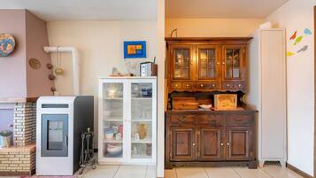 Eine Küche mit einem Kühlschrank, einem Schrank mit Glastüren und einem Holzkasten mit Schubladen.