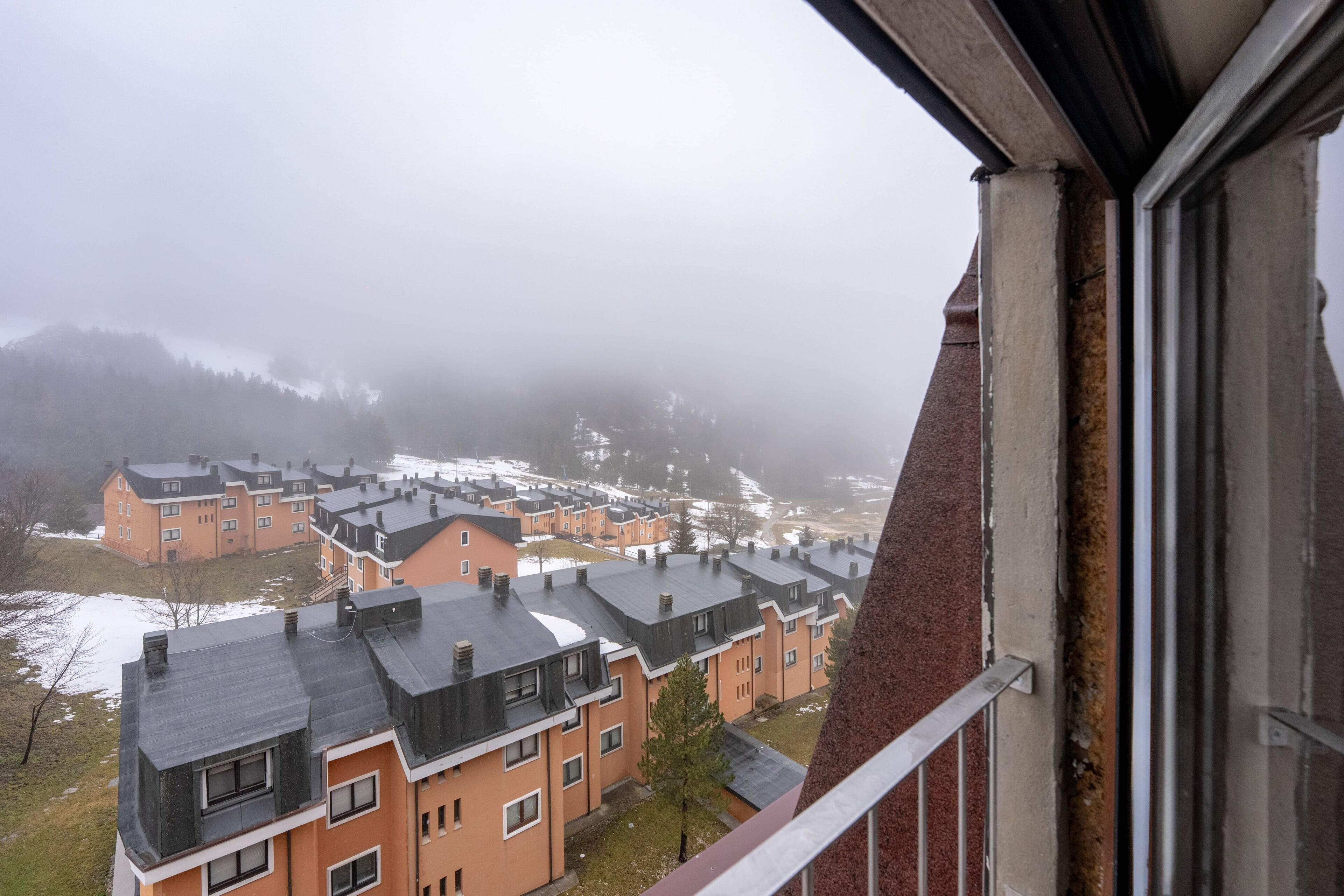 Un quartier résidentiel avec des immeubles à plusieurs étages, des balcons bien visibles et une atmosphère brumeuse.