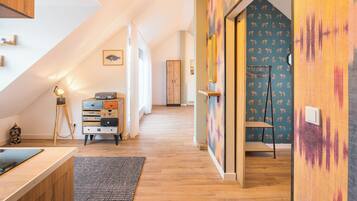 Ein modernes Interieur mit Holzboden, Schreibtisch mit Lampe, einem Wandmuster und einer Treppe.