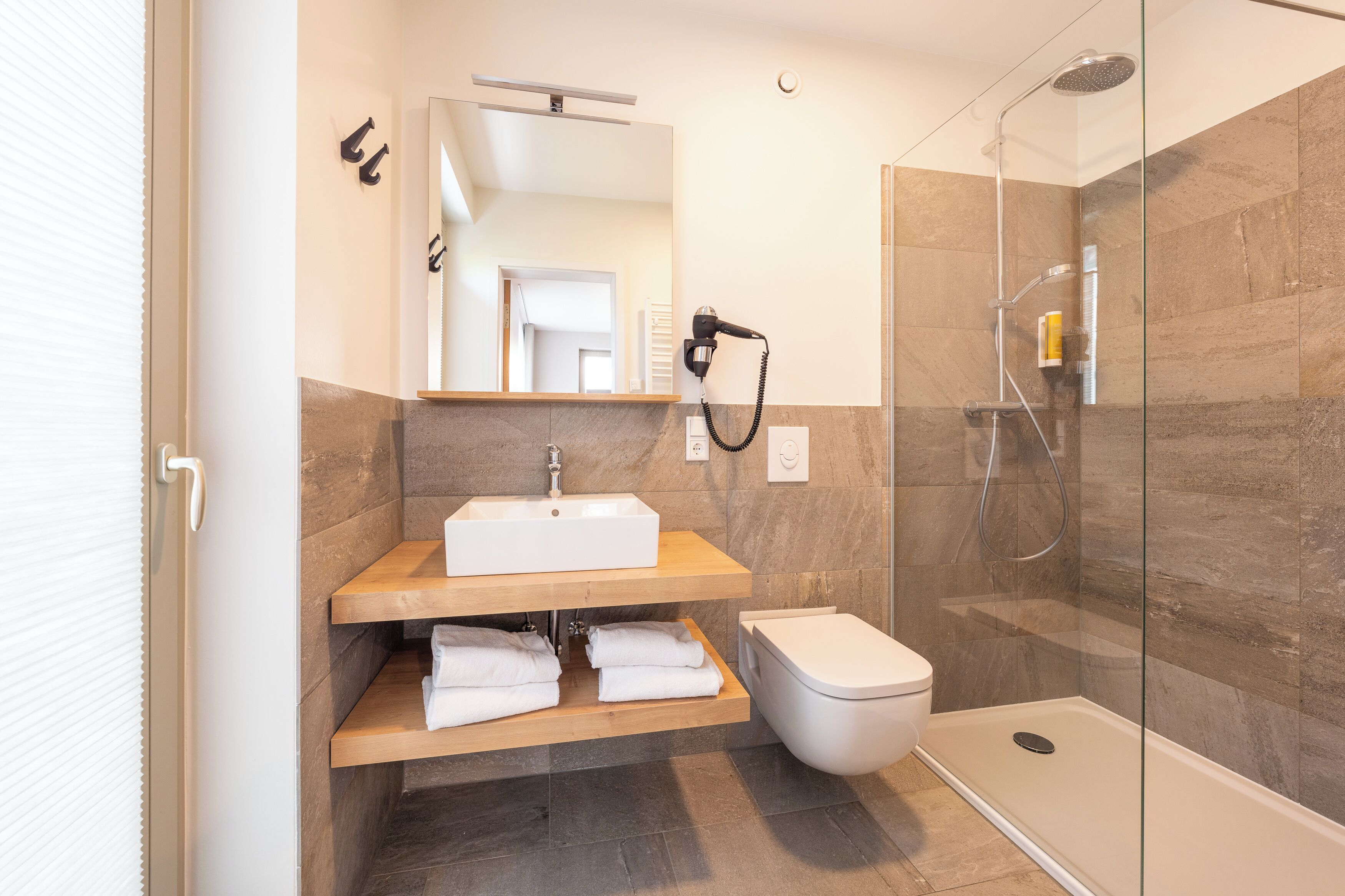 A modern bathroom with a shower, toilet, and sink.