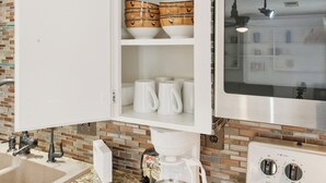 A kitchen with a coffee maker, a microwave, and a cabinet with dishes. - Large 2 Bed Lower Greenville Getaway (Right Side) (Dallas)