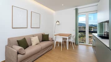 Appartement, balcon, vue ville | Coin séjour | Télévision à écran plat de 32 pouces avec chaînes numériques