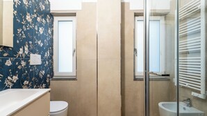 A bathroom with a toilet, a glass-enclosed shower, a sink, and a mirror. - YourHome - Il Nido Apartments  (Sant'Agnello)